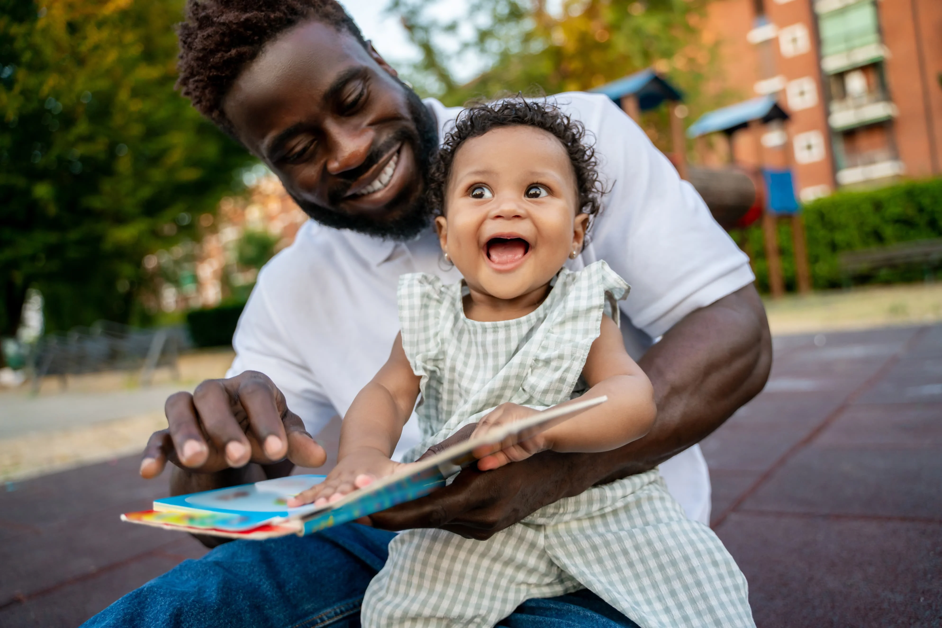 A father reads to his smiling baby