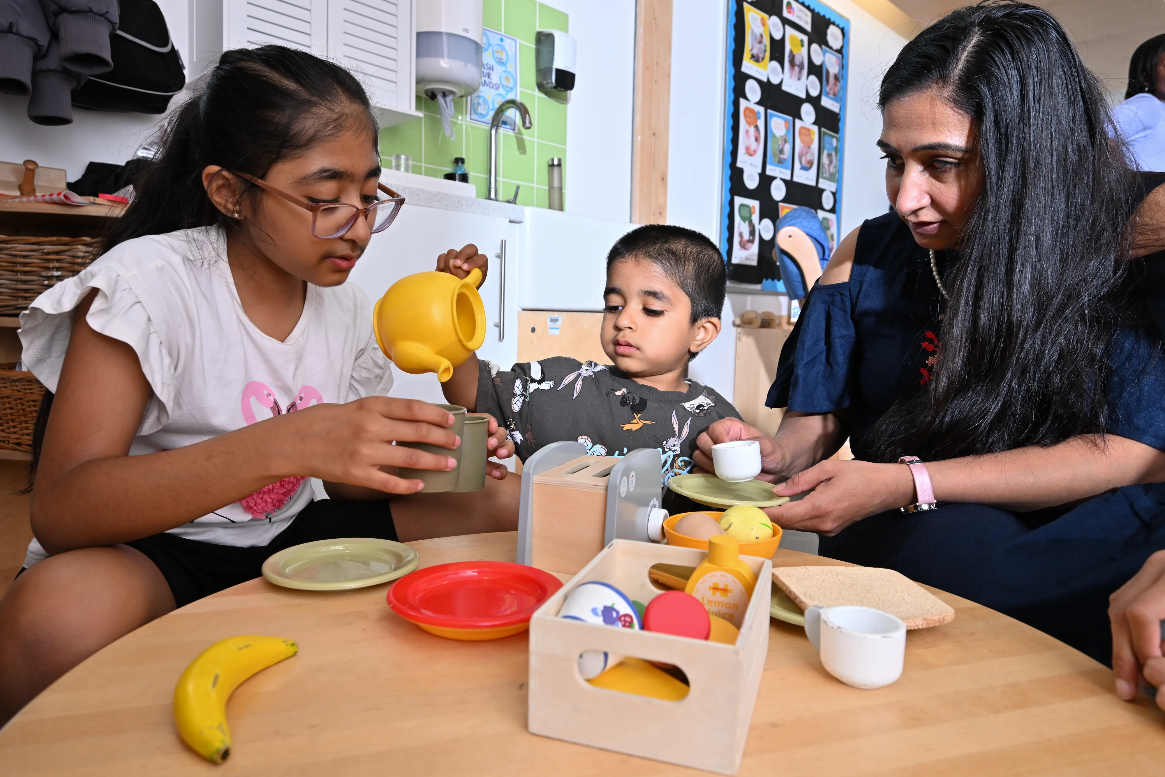 Parent and young children playing with a tea set at the Agar Centre.