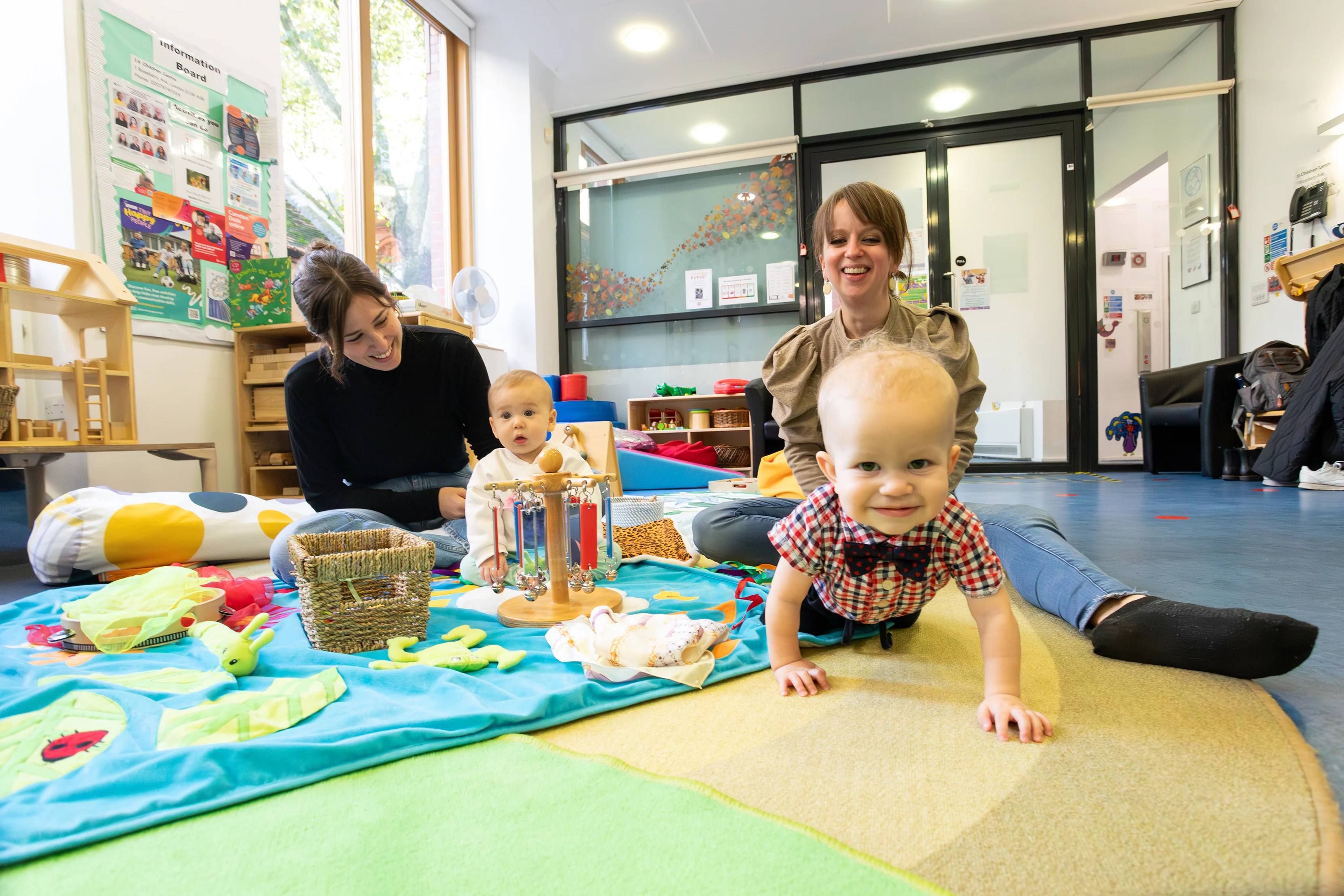 Parents with their two young babies playing.